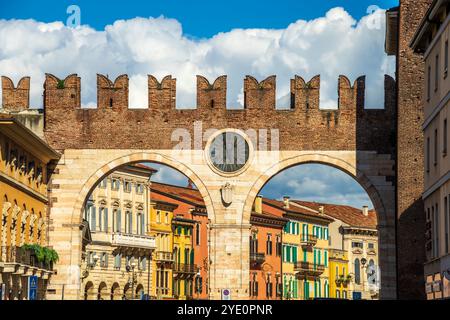 Paysage urbain de Vérone avec murs médiévaux et horloge sur l'ancienne porte de la ville, connue sous le nom de Portoni della Bra, avec vue sur la place principale de la vieille ville en Italie Banque D'Images