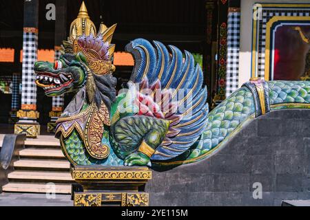 Vibrante statue de dragon finement sculptée monte la garde à l'entrée du temple Tanah Lot, mettant en valeur les riches traditions artistiques et le signe spirituel Banque D'Images