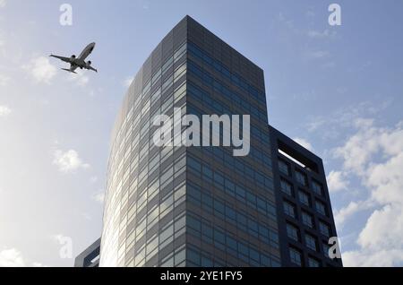 Avion volant au-dessus d'un bâtiment en ville, vue en angle bas Banque D'Images