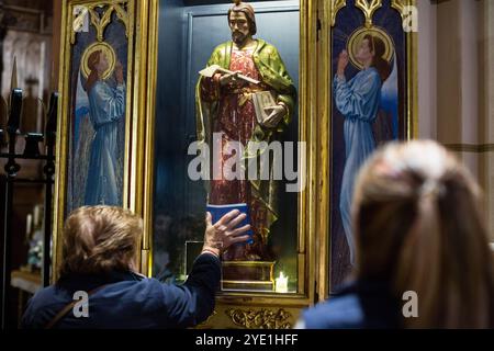 Madrid, Espagne. 28 octobre 2024. Une femme pose sa main sur les pieds de l'image de San Judas Tadeo à l'intérieur de l'Iglesia de Santa Cruz dans le centre de Madrid pendant la célébration de la journée de San Judas Tadeo. Chaque 28 octobre, la journée de Saint Jude Thaddeus est célébrée, le saint patron des causes perdues et difficiles. Cette année, pour la première fois, l'image de Saint Jude Thaddeus participe à une procession depuis l'église de Santa Cruz, pour visiter les rues de Madrid. (Photo de Luis Soto/SOPA images/SIPA USA) crédit : SIPA USA/Alamy Live News Banque D'Images