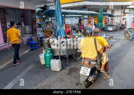 SAMUT PRAKAN, THAÏLANDE, 16 JUIN 2024, les gens regardent l'offre d'un stand de rue avec de la nourriture thaïlandaise, en fin d'après-midi Banque D'Images