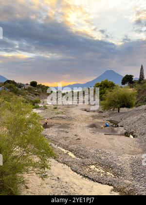 PANAJACHEL, GUATEMALA - DÉCEMBRE 26 2022 : des hommes non identifiés travaillent dans la rivière qui divise la ville de Panajachel, extrayant du sable et de la roche pour construction Banque D'Images