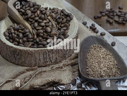 Grains de café dans une cuillère en bois sur un bol en bois rond et café instantané dans une cuillère en bois sur un sac et une planche à découper en bois. Café alternatif pour liv Banque D'Images