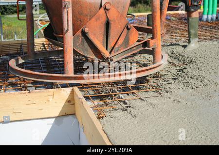 Ouvriers remplissant le sol du deuxième étage avec le béton, le noyau et le bâtiment de construction de coquille Banque D'Images