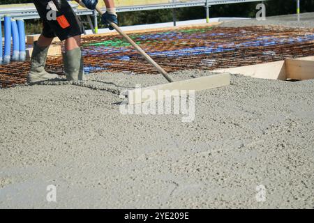 Ouvriers remplissant le sol du deuxième étage avec le béton, le noyau et le bâtiment de construction de coquille Banque D'Images