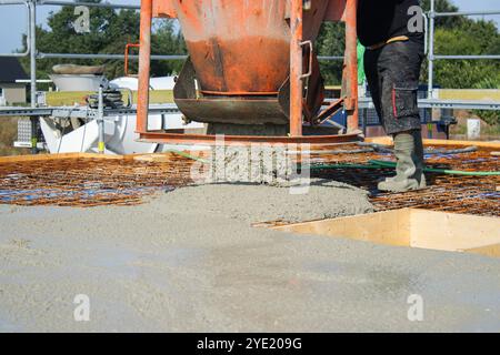 Ouvriers remplissant le sol du deuxième étage avec le béton, le noyau et le bâtiment de construction de coquille Banque D'Images