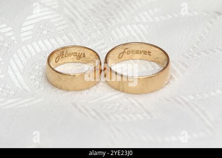 Anneaux de mariage dorés sur nappe blanche Banque D'Images