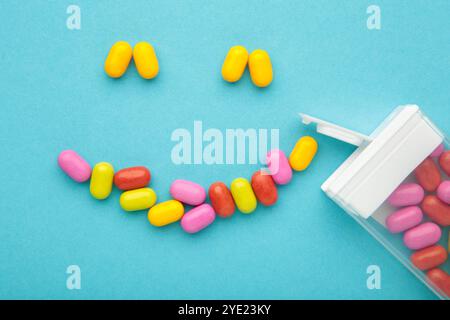 Les bonbons aux fruits colorés se présentent sous la forme d'un sourire sur fond bleu. Vue de dessus Banque D'Images