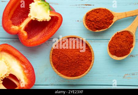 Poudre de paprika avec du poivre rouge frais sur fond bleu. Vue de dessus Banque D'Images