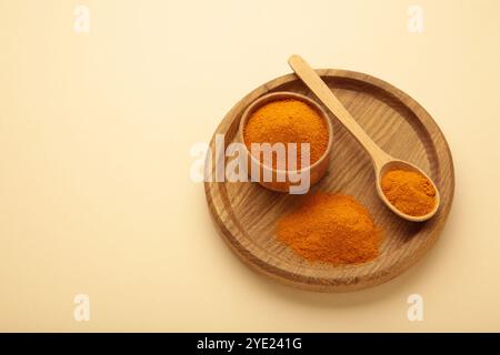 Poudre sèche de curcuma (curcuma longa linn) sur fond beige. Vue de dessus Banque D'Images