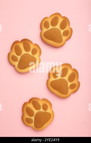 Cookies de patte de chat auto-faits sur fond rose. Vue de dessus Banque D'Images