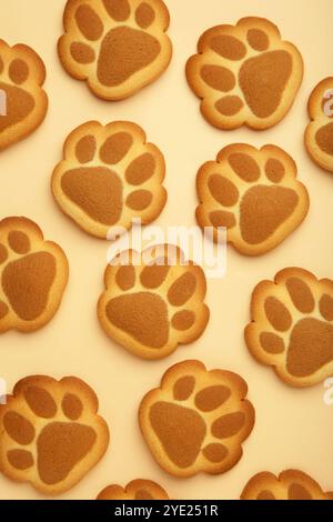 Cookies de patte de chat auto-faits sur fond beige. Vue de dessus Banque D'Images