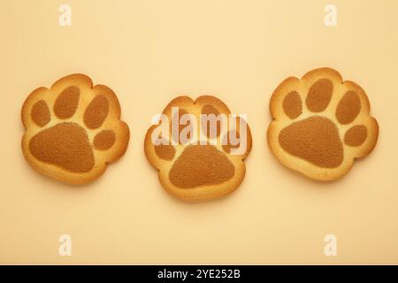 Cookies de patte de chat auto-faits sur fond beige. Vue de dessus Banque D'Images