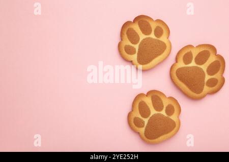 Cookies de patte de chat auto-faits sur fond rose. Vue de dessus Banque D'Images