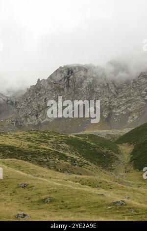 Cette photographie orientée verticalement capture une scène automnale tranquille dans les montagnes géorgiennes en plein jour. Les falaises accidentées, texturées de rochers Banque D'Images