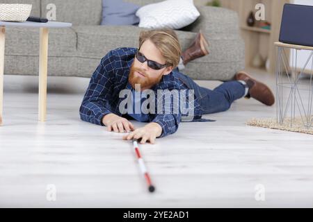 jeune aveugle tombant par terre Banque D'Images