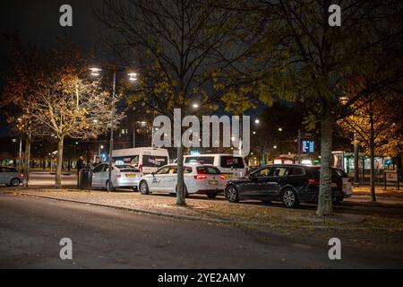 Taxis stationnés devant la gare un samedi soir en octobre 2024 à Norrköping, Suède. Banque D'Images