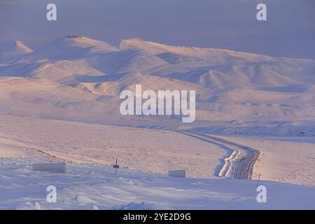 Route, route de gravier, autoroute, glacé, enneigé, paysage de montagne, lumière du matin, route Dempster, Territoires du Nord-Ouest, Canada, Amérique du Nord Banque D'Images