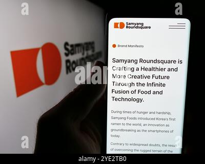 Allemagne. 25 juin 2024. Dans cette illustration photo, une personne tient un smartphone avec la page Web de la société alimentaire sud-coréenne Samyang Roundsquare Co. Ltd avec logo. Crédit : SOPA images Limited/Alamy Live News Banque D'Images