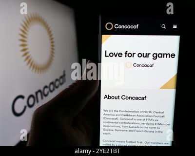 Allemagne. 25 juin 2024. Dans cette illustration photo, une personne tient un téléphone portable avec la page Web de l'association de football CONCACAF devant le logo. Crédit : SOPA images Limited/Alamy Live News Banque D'Images