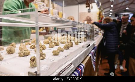 Au Festival de la truffe d'Alba en Italie, les participants admirent diverses truffes exposées, s'engagent avec des vendeurs et profitent de l'atmosphère animée remplie de Banque D'Images