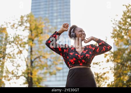Jeune femme écoutant de la musique avec des écouteurs dans la ville Banque D'Images