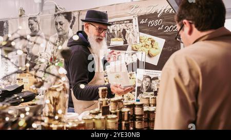 Au Festival de la truffe d'Alba en Italie, les visiteurs s'engagent avec des vendeurs locaux, explorant divers produits de la truffe. Banque D'Images