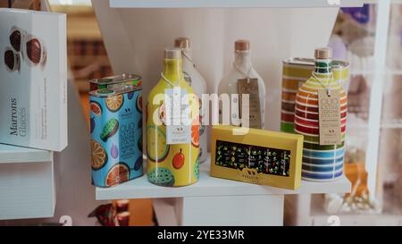 Des bouteilles colorées et des canettes d'huiles gourmandes sont soigneusement disposées sur l'affichage dans un magasin à Alba, en Italie, mettant en valeur les saveurs locales et l'emballage unique des Banque D'Images