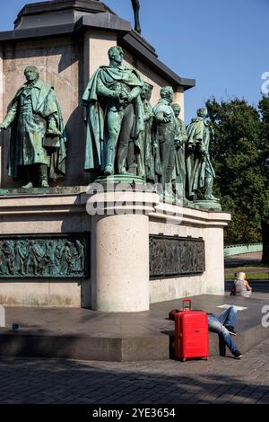 Un homme avec un chariot rouge se trouve à la statue équestre Empereur Friedrich Wilhem III, roi de Prusse au Heumarket, statues sur le piédestal, Cologn Banque D'Images