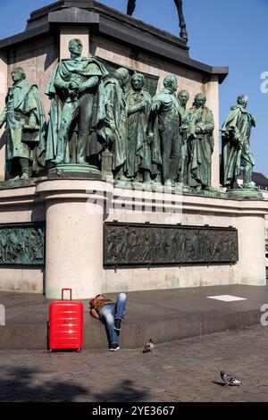 Un homme avec un chariot rouge se trouve à la statue équestre Empereur Friedrich Wilhem III, roi de Prusse au Heumarket, statues sur le piédestal, Cologn Banque D'Images