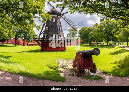 Vue sur le Kastelsmøllen, un moulin à vent de type hollandais dans le Kastellet, une citadelle du XVIIe siècle à Copenhague, Danemark, avec un canon au premier plan. Banque D'Images