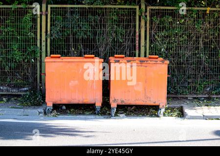 Deux poubelles orange. Concept d'idée de recyclage. Grandes poubelles avec couvercles à charnières. Photo horizontale. Pas de gens, personne. Extérieur. Banque D'Images