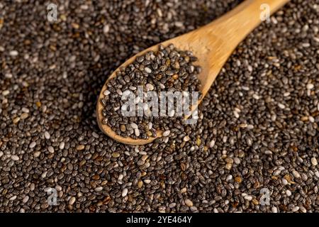 cuillère en bois et graines de chia , un grand nombre de graines de chia à ajouter aux yaourts, desserts et autres produits alimentaires Banque D'Images