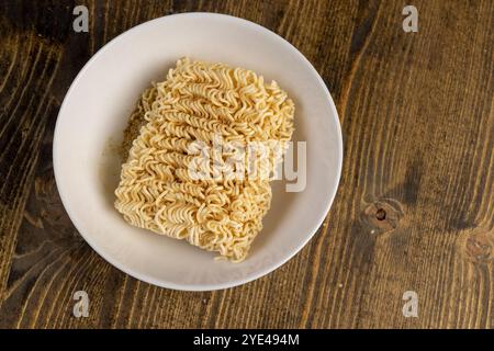 séchez les nouilles roulées aux œufs pendant la cuisson dans un bol blanc, détails des nouilles à la farine avec des œufs pendant la cuisson Banque D'Images