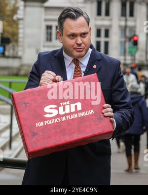 Londres, Royaume-Uni. 29 octobre 2024. Harry Cole, rédacteur politique du journal 'Sun', est vu devant le Trésor à Westminster aujourd'hui, filmant une vidéo de budget 'simulée' avec une boîte de budget rouge avec le logo Sun. Plusieurs radiodiffuseurs et journalistes sont rassemblés en dehors du Trésor avant le budget de demain, qui sera présenté par la chancelière Rachel Reeves. Crédit : Imageplotter/Alamy Live News Banque D'Images