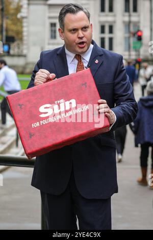 Londres, Royaume-Uni. 29 octobre 2024. Harry Cole, rédacteur politique du journal 'Sun', est vu devant le Trésor à Westminster aujourd'hui, filmant une vidéo de budget 'simulée' avec une boîte de budget rouge avec le logo Sun. Plusieurs radiodiffuseurs et journalistes sont rassemblés en dehors du Trésor avant le budget de demain, qui sera présenté par la chancelière Rachel Reeves. Crédit : Imageplotter/Alamy Live News Banque D'Images