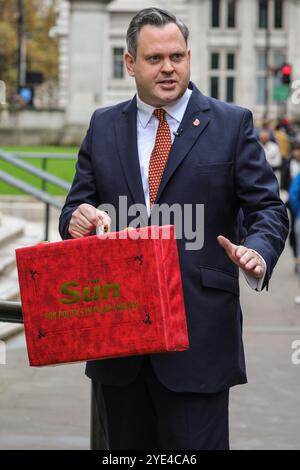 Londres, Royaume-Uni. 29 octobre 2024. Harry Cole, rédacteur politique du journal 'Sun', est vu devant le Trésor à Westminster aujourd'hui, filmant une vidéo de budget 'simulée' avec une boîte de budget rouge avec le logo Sun. Plusieurs radiodiffuseurs et journalistes sont rassemblés en dehors du Trésor avant le budget de demain, qui sera présenté par la chancelière Rachel Reeves. Crédit : Imageplotter/Alamy Live News Banque D'Images