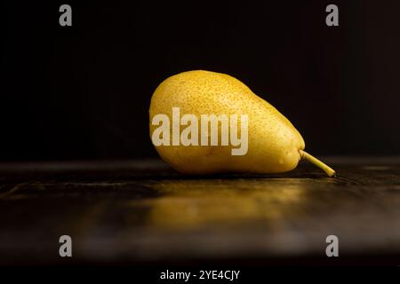 poire jaune-rouge mûre humide sur la table, délicieuses poires jaunes aux côtés rouges recouvertes de gouttes d'eau Banque D'Images