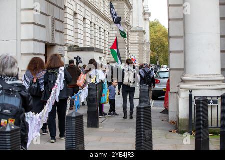 Londres, Royaume-Uni. 29 octobre 2024. Parents et enfants de Global Women's Strike et parents for Palestine exposent des centaines de vêtements de bébé pour souligner le nombre de morts parmi les enfants tués par Israël pendant la guerre contre Gaza devant le bureau des Affaires étrangères et du commonwealth crédit : Richard Lincoln/Alamy Live News Banque D'Images