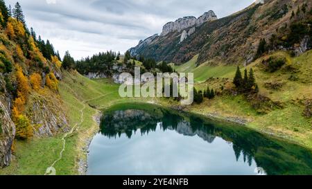 Niché au milieu de superbes montagnes, Falensee reflète les couleurs vibrantes de la nature. Les teintes automnales peignent le paysage tandis que les visiteurs marchent le long de sentiers paisibles, imprégnés de l'atmosphère tranquille. Banque D'Images