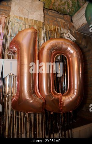 Grande décoration de ballon en or rose 10 dans une ambiance festive. Banque D'Images