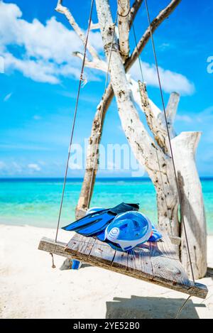 Nageoires, une serviette et un masque sous-marin sur l'oscillation sur la rive de l'océan Indien. Îles Maldives. Banque D'Images