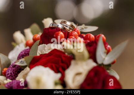 Magnifique bouquet de mariage avec anneaux et fleurs colorées. Banque D'Images