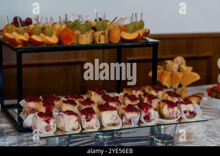 Présentation élégante de pâtisseries assorties et de fruits frais au buffet. Banque D'Images