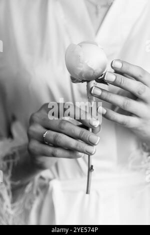 Élégant Portrait noir et blanc d'une femme tenant une fleur. Banque D'Images