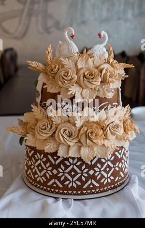 Elégant gâteau de mariage avec surmatelas de cygne et décoration florale. Banque D'Images