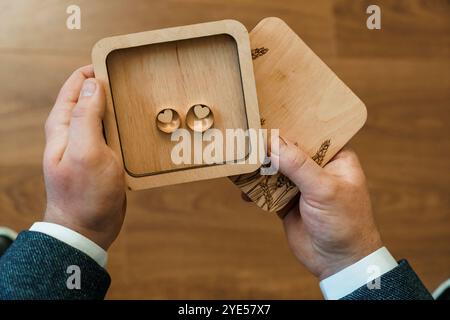 Élégante boîte en bois contenant des anneaux de mariage en forme de coeur. Banque D'Images