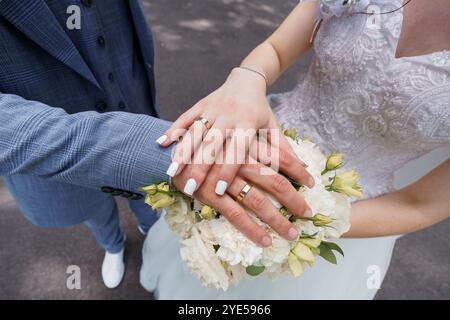 Un moment de mariage romantique avec des mains entrelacées et bouquet floral. Banque D'Images