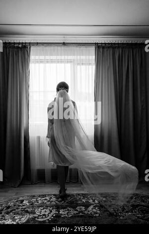 Mariée éthéré dans la lumière naturelle se préparant pour le jour du mariage. Banque D'Images