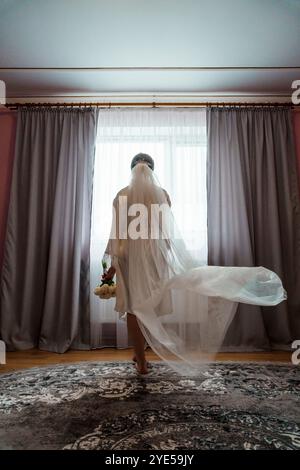 Mariée élégante se préparant pour le jour du mariage dans un cadre intérieur serein. Banque D'Images